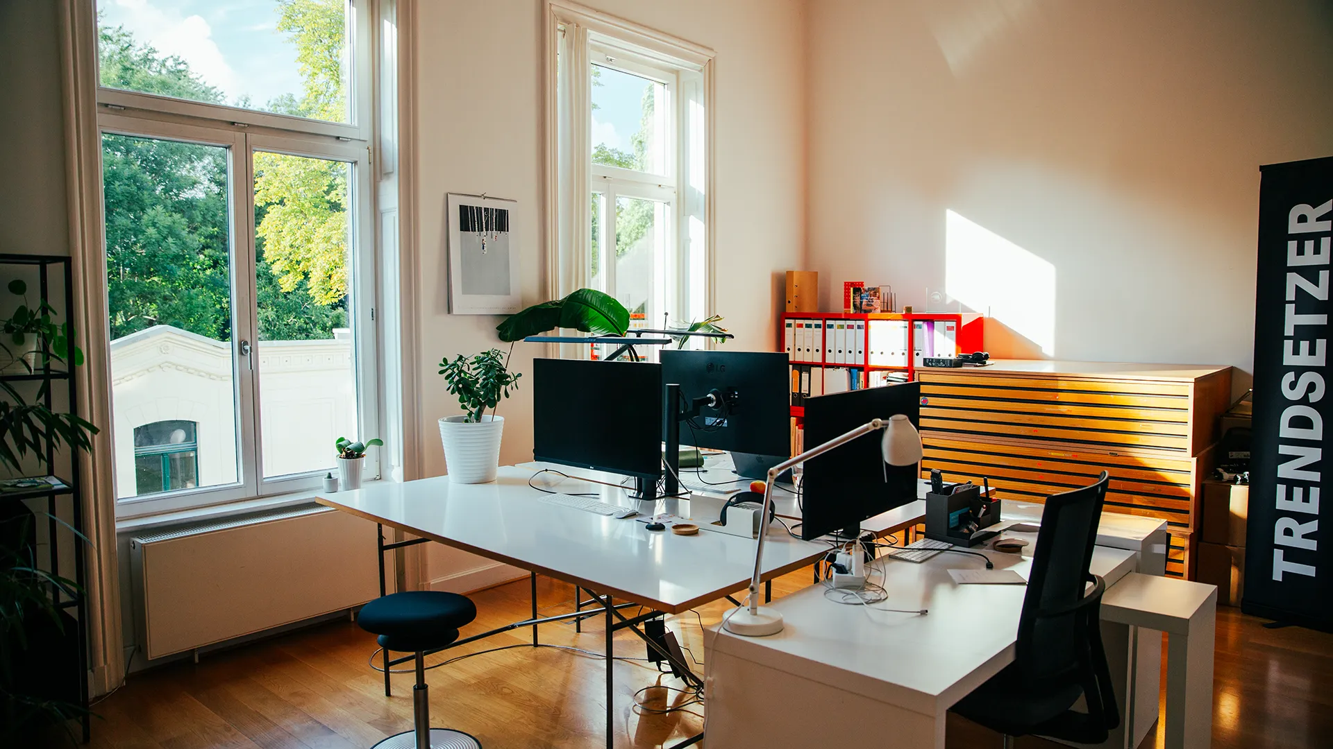 Modern eingerichteter Arbeitsplatz bei Trendsetzer in Leipzig mit Schreibtischen, Monitoren und Pflanzen im hellen Büro.